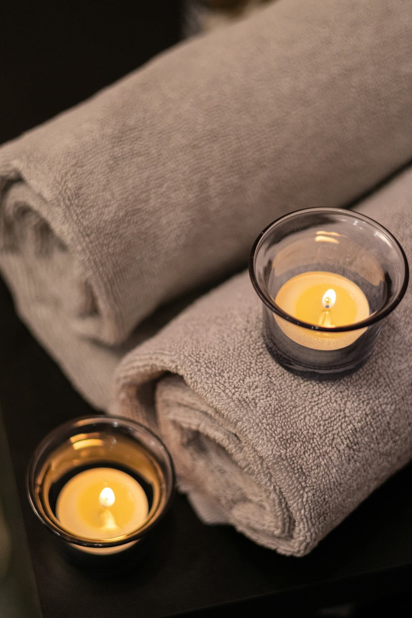 Folded towels and candlelight in a quiet treatment room