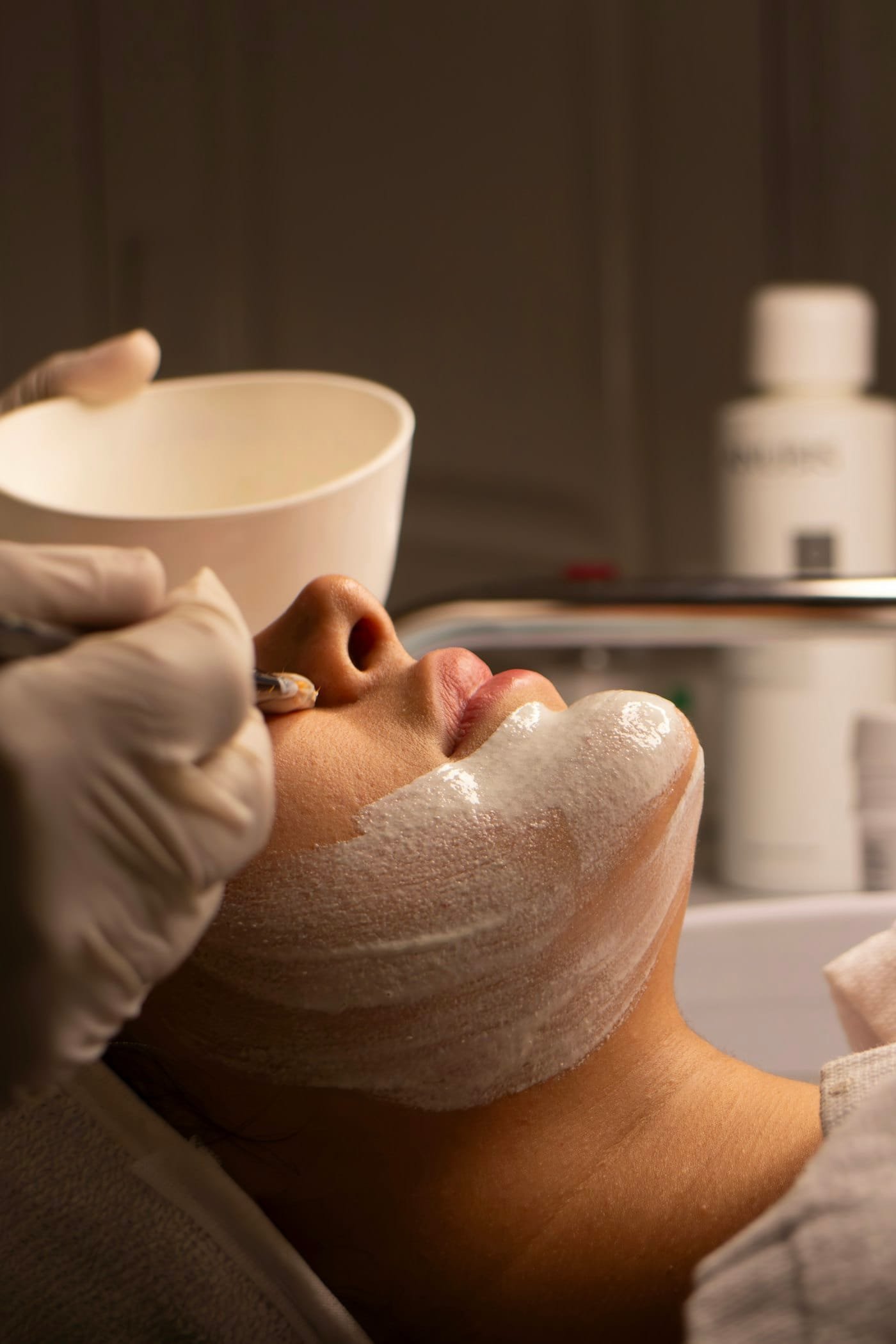 A client relaxing under a hydrating mask during a facial at Oasis