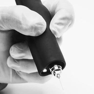 A gloved hand holding the Plasma Corrective Pen