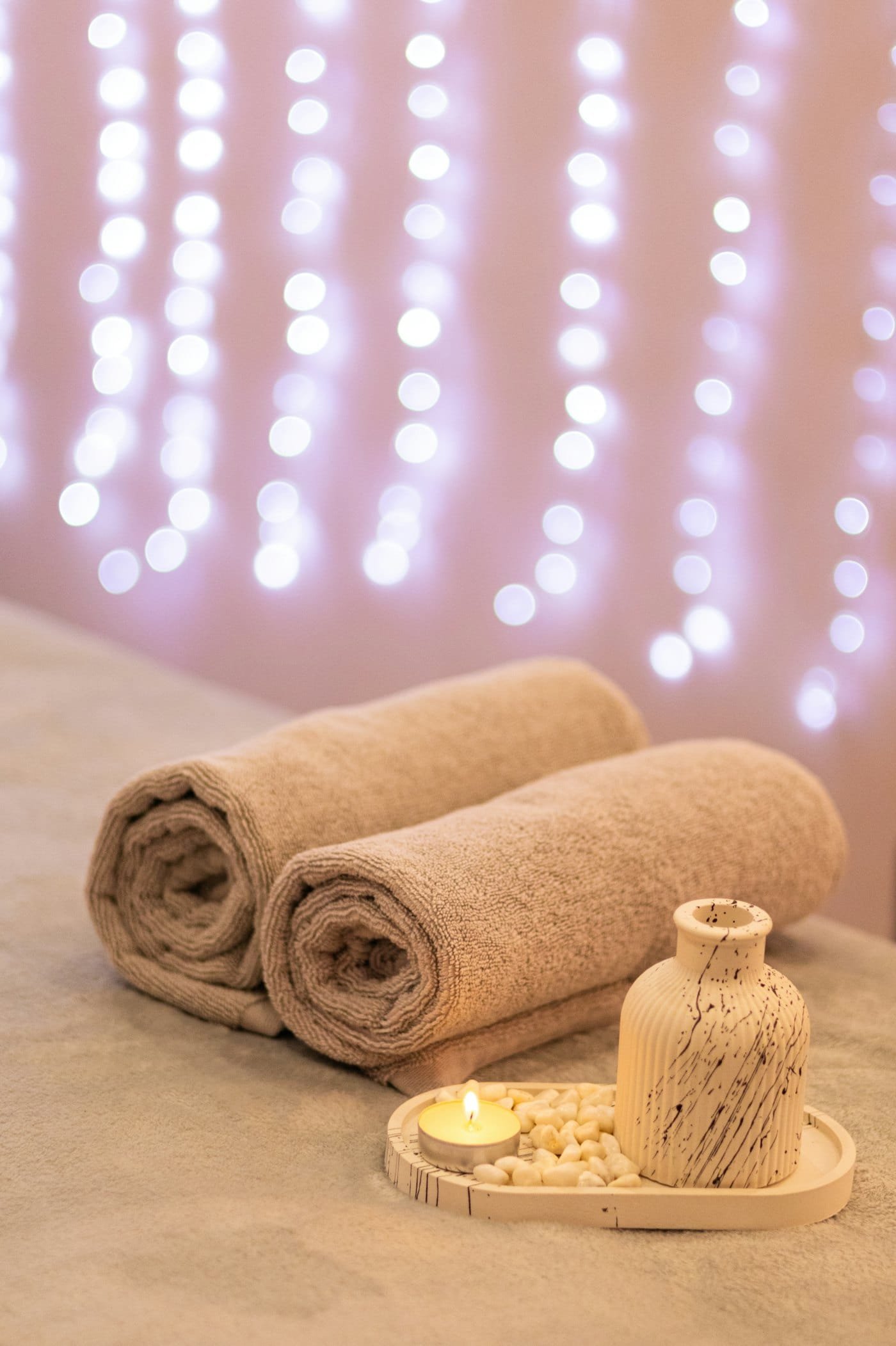 Rolled white towels stacked beside the treatment bed